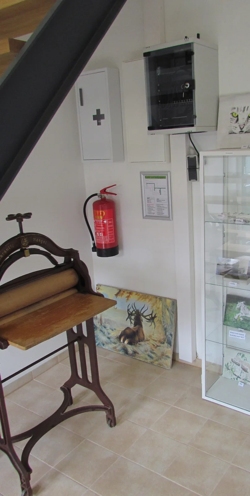 Flur mit Vitrine und historischer Wäschemangel